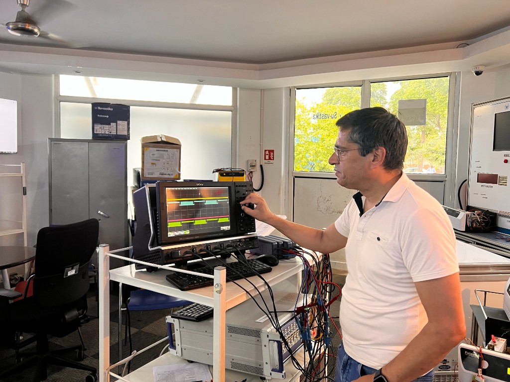 Kunwer Sachdev at an oscilloscope in an R&D lab